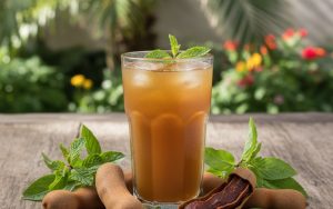 Verre de jus de tamarin frais avec des fruits de tamarin en arrière-plan.